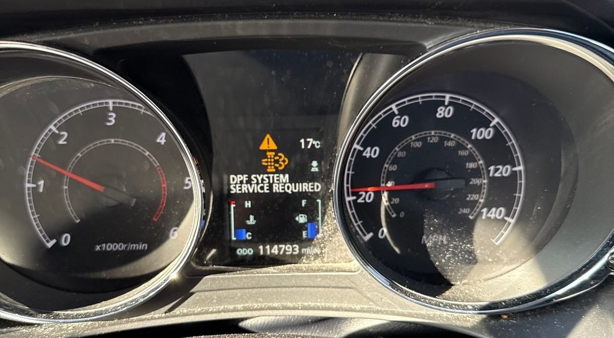 Diesel dashboard showing DPF SYSTEM SERVICE REQUIRED with the DPF warning symbol lit