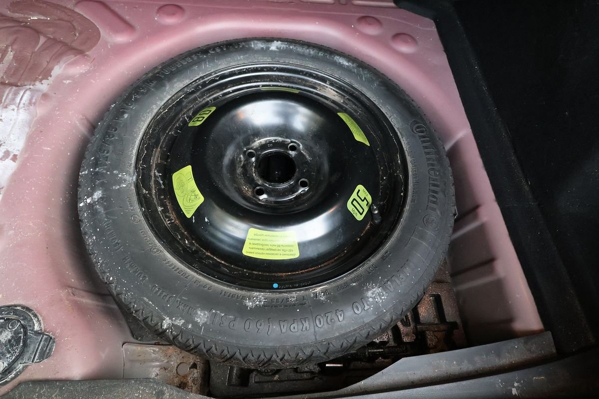 Under a boot floor: the spare wheel and surface rust in the wheel well